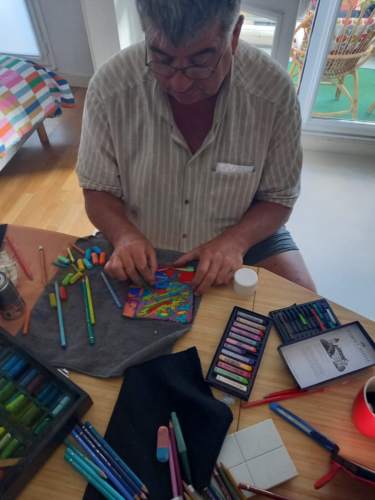 Éric Bailblé dans son atelier, un pastel abstrait à la main