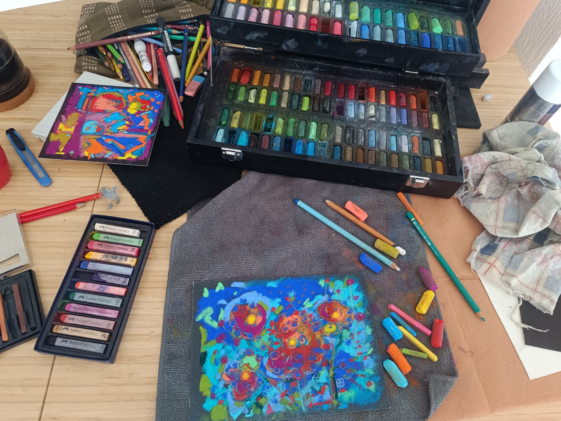 La table de l’atelier : deux pastels abstraits et les boîtes de craies